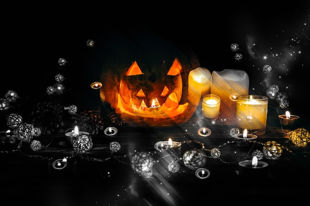 Zucca di Halloween nell'oscurità. Luci lampade e candele. Mistica vacanza autunnale. Dettagli festivi. La tradizione del dolcetto o scherzetto. Ognissanti in ottobre.