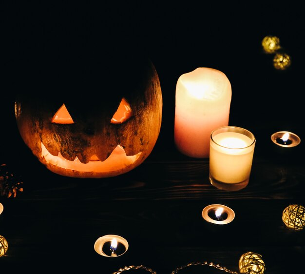 Zucca di Halloween nell'oscurità. Luci lampade e candele. Mistica vacanza autunnale. Dettagli festivi. La tradizione del dolcetto o scherzetto. Ognissanti in ottobre.