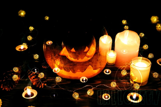 Zucca di Halloween nell'oscurità. Luci lampade e candele. Mistica vacanza autunnale. Dettagli festivi. La tradizione del dolcetto o scherzetto. Ognissanti in ottobre.