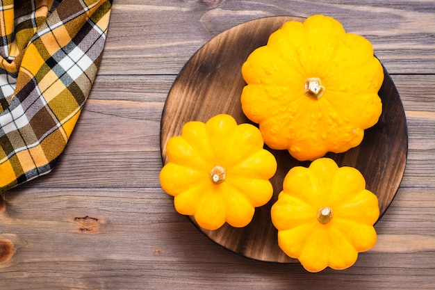 Zucca fresca di tre cespugli su un tagliere su fondo di legno