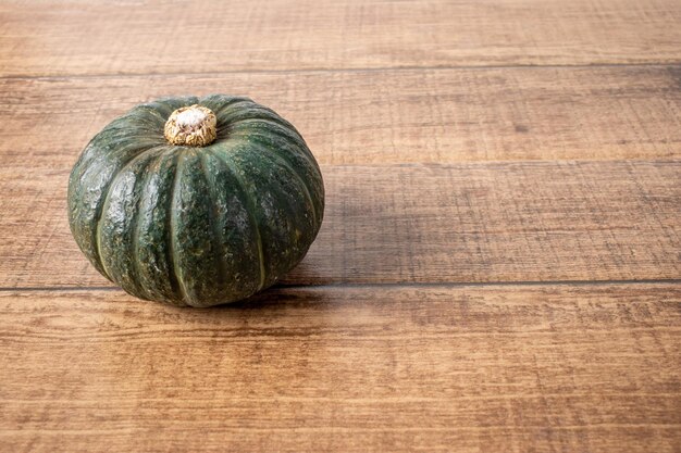 Zucca giapponese verde su fondo di legno