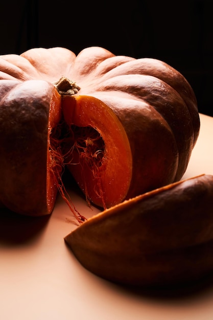 Zucca matura affettata da vicino su sfondo arancione