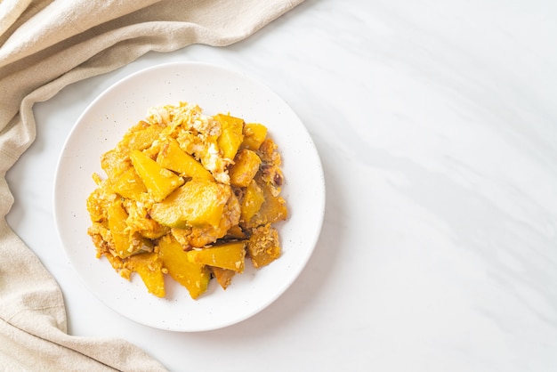 Zucca saltata in padella con uovo su piatto bianco