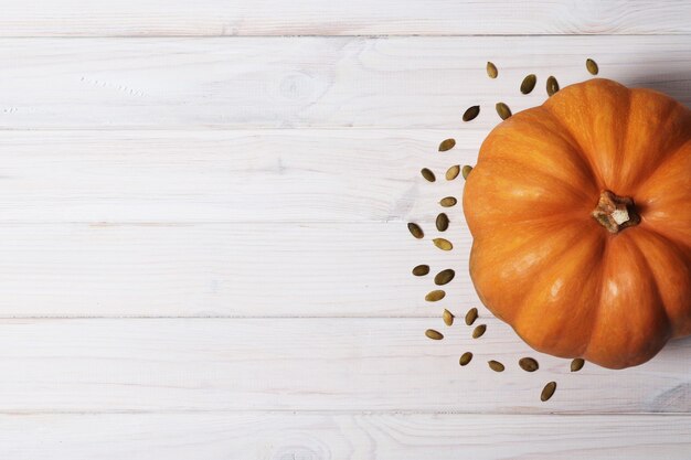 Zucca sul legno. Semi di zucca sul piatto. Copia spazio