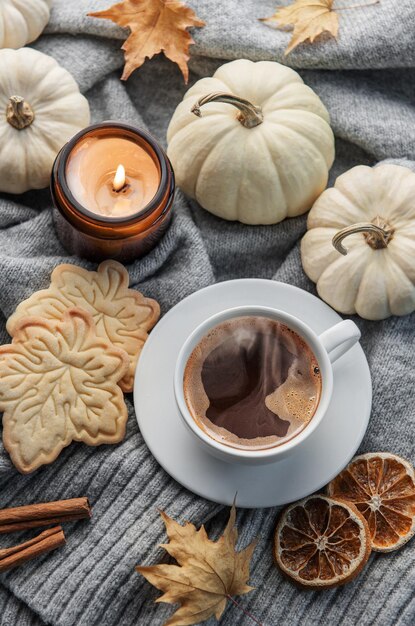 Zucche bianche caffè e foglie autunnali