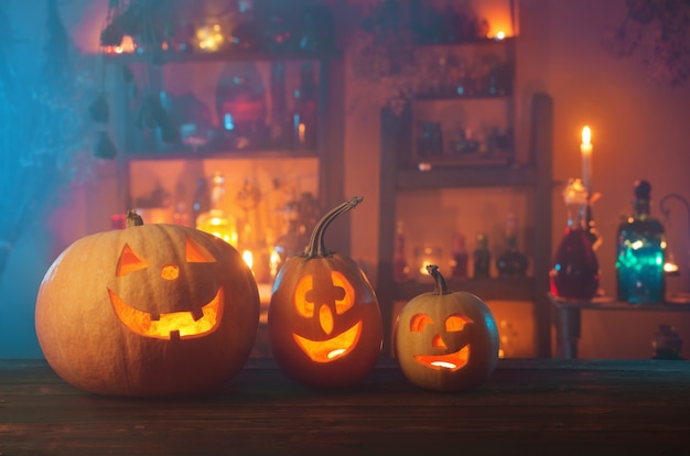 Zucche di Halloween con candele e pozioni magiche di notte al coperto