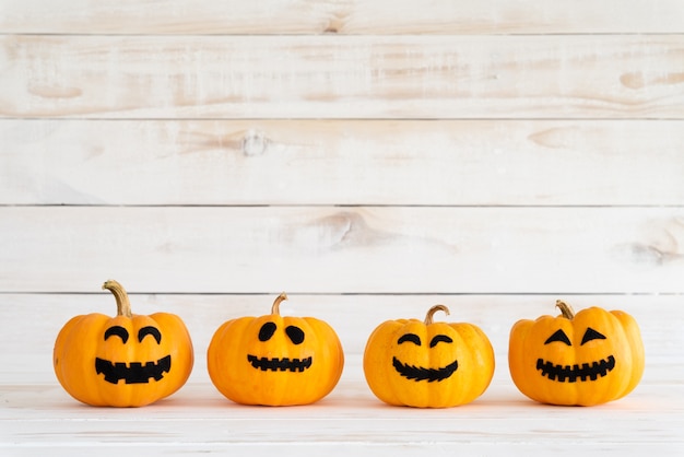 Zucche gialle del fantasma sul fondo bianco del bordo di legno con il pipistrello. concetto di Halloween