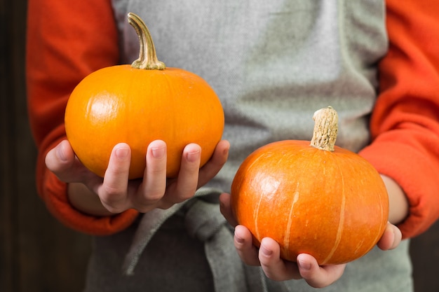 Zucche in mano. Composizione autunnale