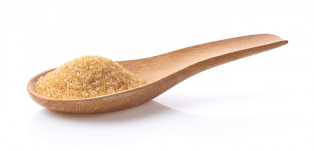 Zucchero bruno in cucchiaio di legno su fondo bianco