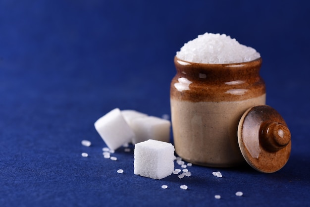 Zucchero. zucchero bianco semolato e zucchero raffinato su una superficie blu