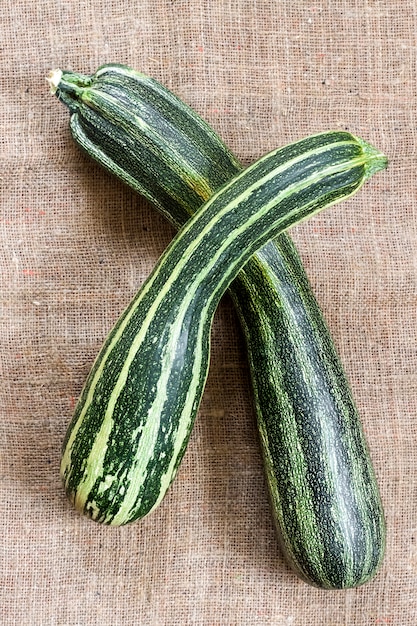 Zucchine a strisce fresche su tela di sacco