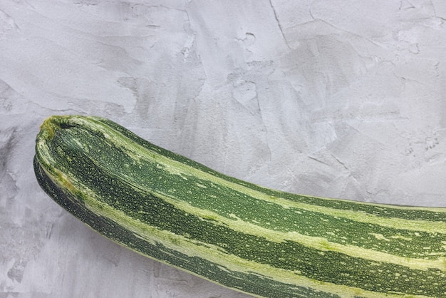 Zucchine a strisce verdi fresche su sfondo grigio