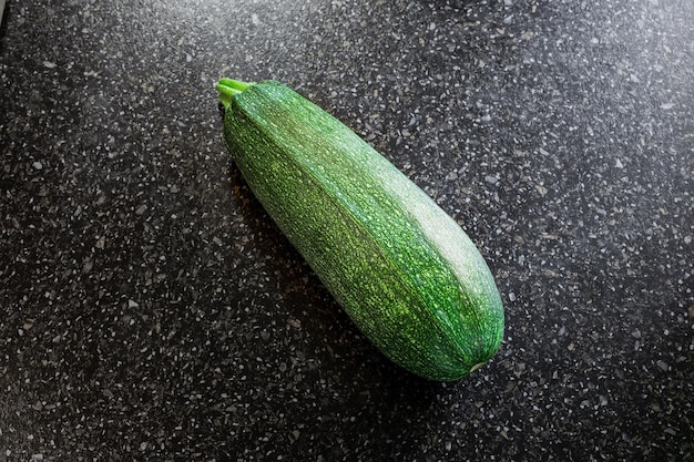 Zucchine a strisce verdi su sfondo nero Raccolto estivo di verdure