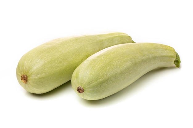 Zucchine bianche fresche con pezzi a fette su sfondo bianco.