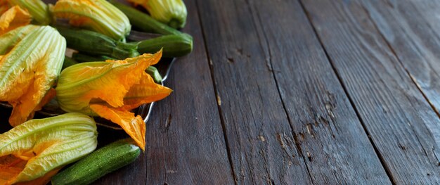 Zucchine e fiori di zucca su un tavolo di legno