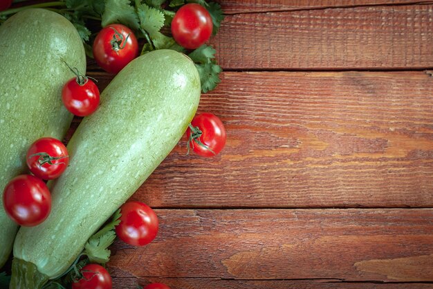 Zucchine e pomodori su fondo di legno