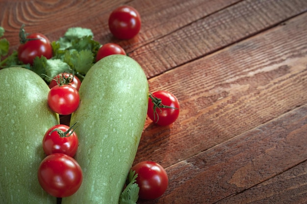 Zucchine e pomodori su fondo di legno