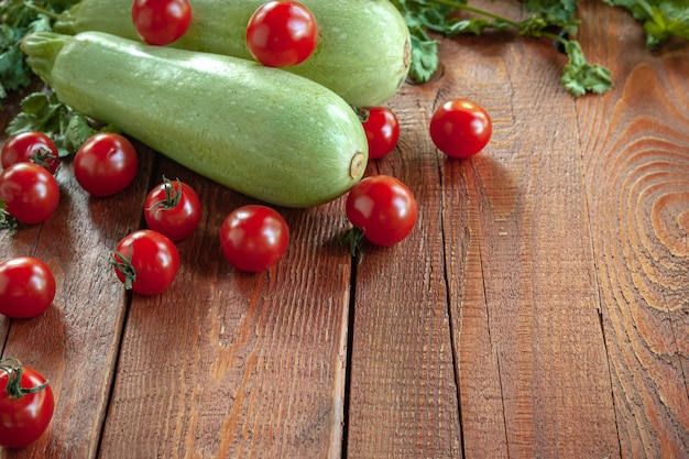 Zucchine e pomodori su fondo di legno