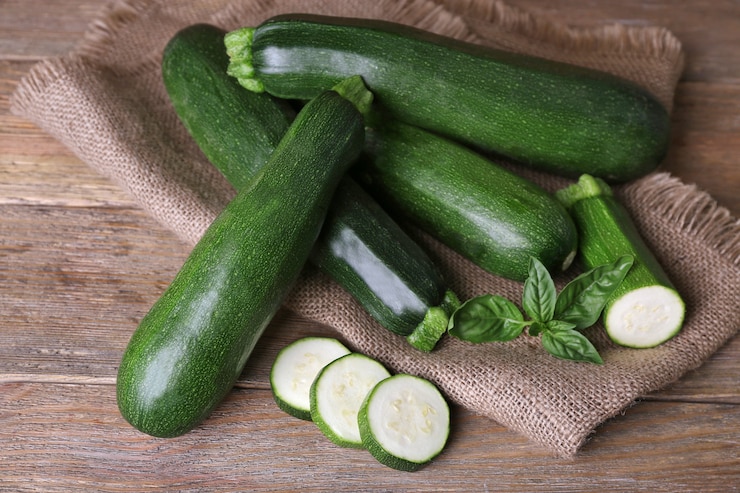 Foto zucchine fresche con basilico sul tavolo di legno da vicino