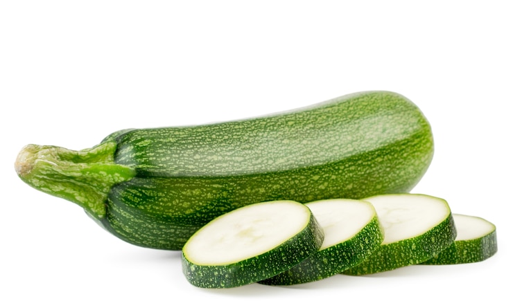 Foto zucchine fresche e fette affettate vicino isolato