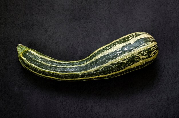 Zucchine fresche su sfondo nero con texture