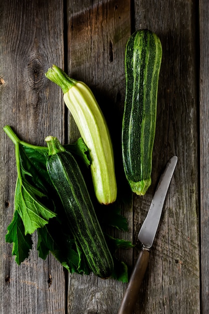 Zucchine fresche verdi su una vecchia superficie di legno