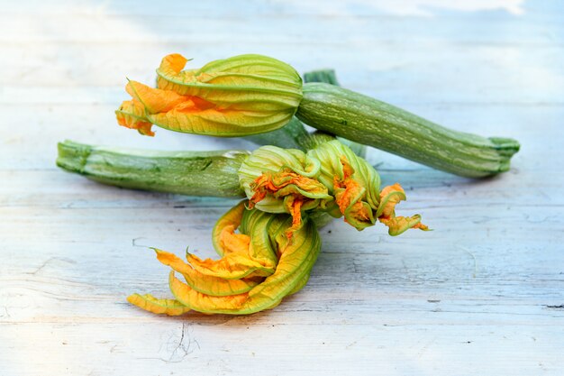 Zucchine giovani con fiori attaccato su un tavolo