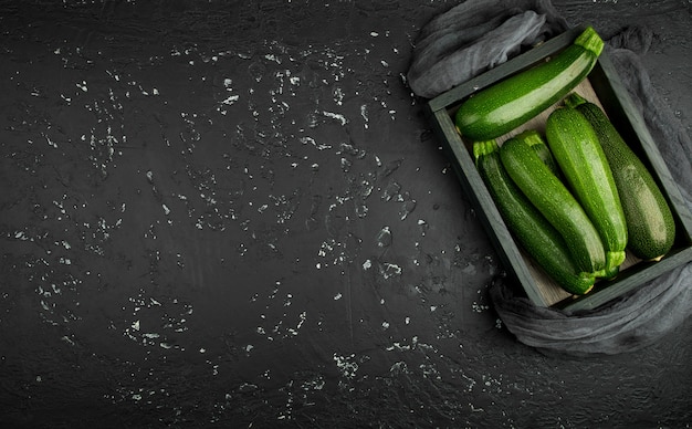 Zucchine verdi fresche su un vassoio scuro