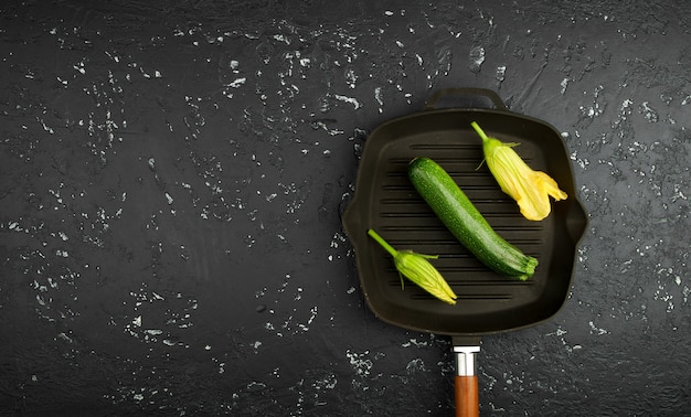 Zucchine verdi fresche su una tavola scura. La vista dall'alto. Copia spazio.