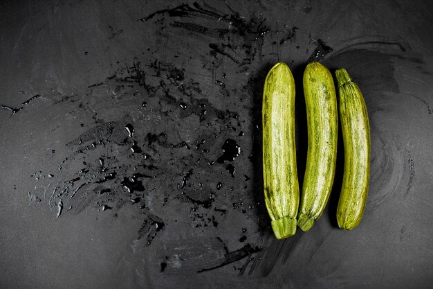 Zucchini fresco verde fresco sul fondo della lavagna.