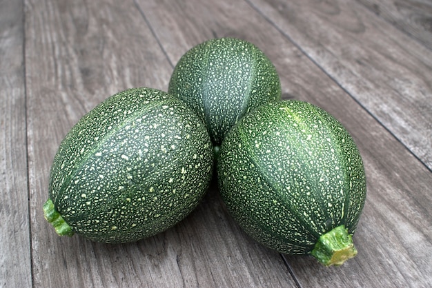 Zucchino rotondo su fondo di legno.