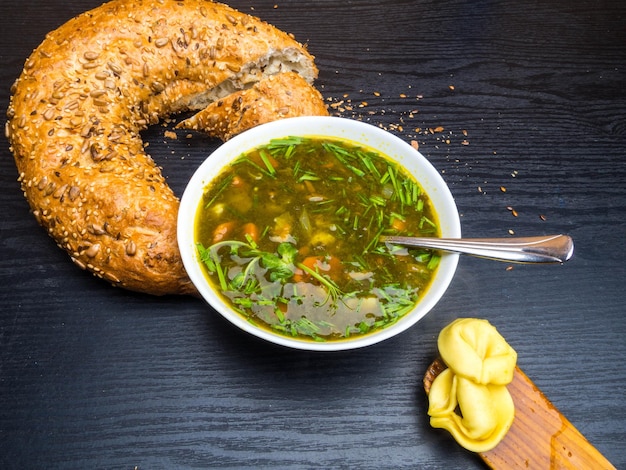 Zuppa calda di acetosella e spinaci con pane e gnocchi su fondo di legno
