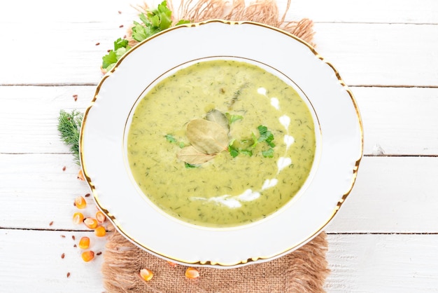 Zuppa con broccoli e piselli e verdure in una ciotola Cibo sano Su uno sfondo di legno bianco Vista dall'alto Copia spazio per il testo