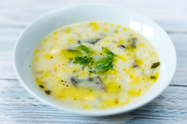 Zuppa con funghi e burro piatto bianco su sfondo bianco