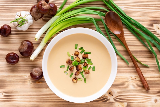 Zuppa crema tradizionale di castagne su un tavolo di legno. Vista dall'alto.