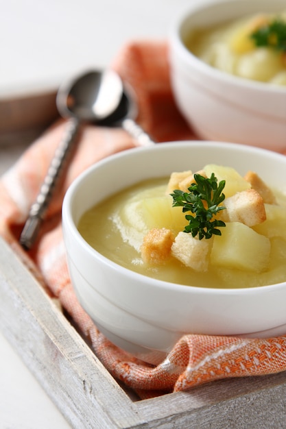 Zuppa cremosa di patate dolci con crostini di pane e prezzemolo in una ciotola bianca