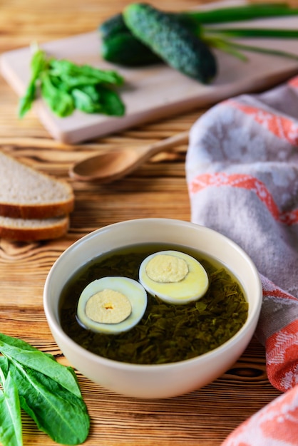 Zuppa di acetosa con uova sode su un tavolo di legno.