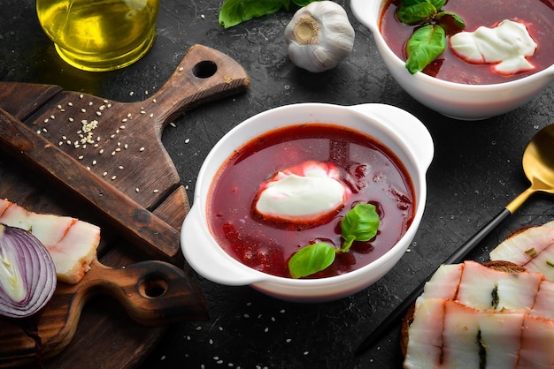 Zuppa di barbabietola. Borsch tradizionale ucraino con panna acida e un panino di pane nero con lardo. Vista dall'alto.