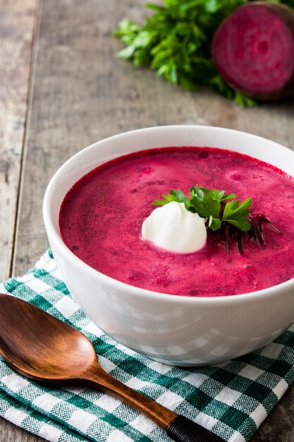 Zuppa di barbabietola in ciotola bianca sulla tavola di legno