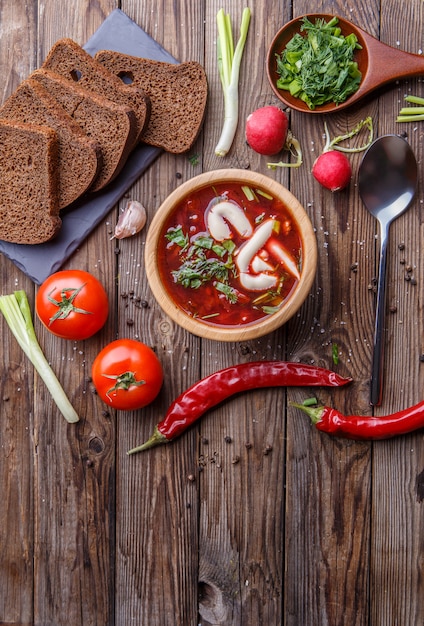 Zuppa di barbabietole in piatto di legno con verdure