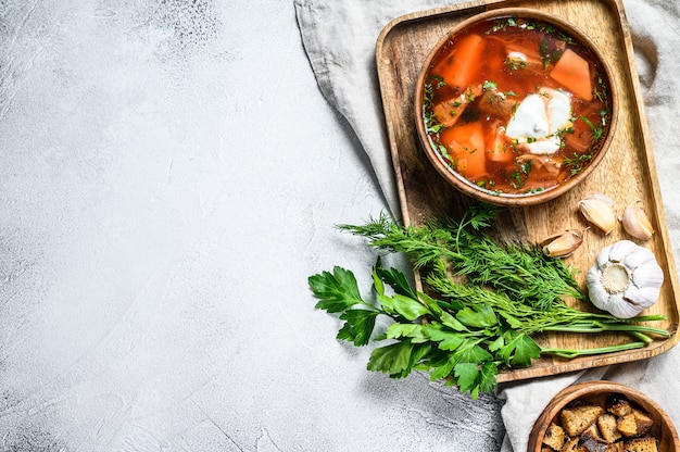 Zuppa di borsch specialità russa con barbabietole e panna acida. Sfondo grigio. Vista dall'alto. Spazio per il testo