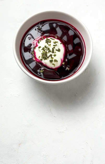 Zuppa di borscht rossa nazionale ucraina e russa tradizionale in una ciotola con panna acida ed erbe Concetto di cibo sano