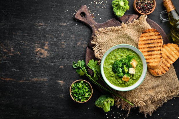 Zuppa di broccoli, crema di spinaci in una ciotola con pane tostato. Zuppa verde. Cibo dietetico. Vista dall'alto.