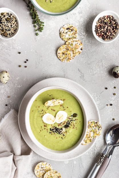 Zuppa di broccoli disintossicante con mix di semi, uovo di quaglia e cracker in ciotola