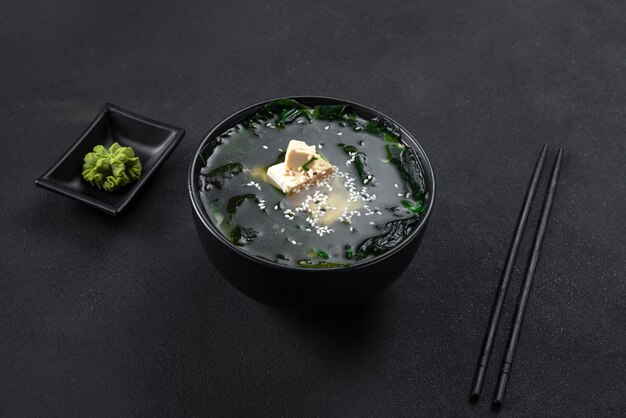 Zuppa di cibo asiatico su sfondo nero in una ciotola nera