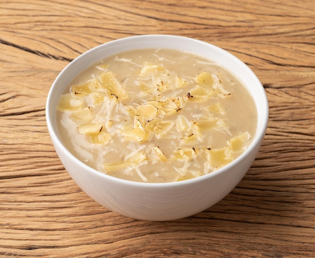 Zuppa di cipolle con formaggio in una ciotola su un tavolo di legno