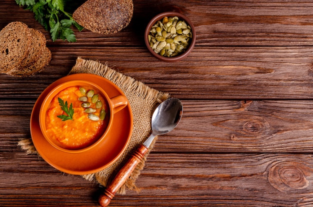 Zuppa di crema autunnale vegetariana di zucche e carote con semi e prezzemolo