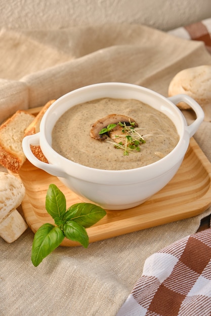 Zuppa di crema con funghi champignon in ciotola bianca