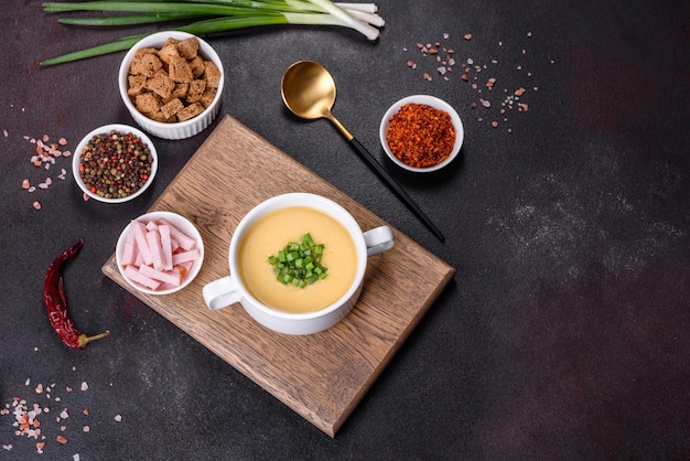 Zuppa di crema con porri di patate e piselli su un tavolo di cemento scuro