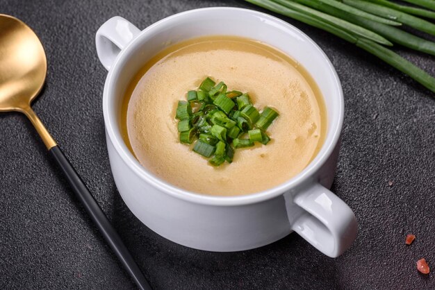 Zuppa di crema con porri di patate e piselli su un tavolo di cemento scuro